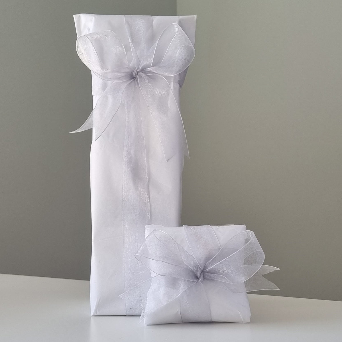 Gift wrapping - white tissue paper with silver ribbon & bow